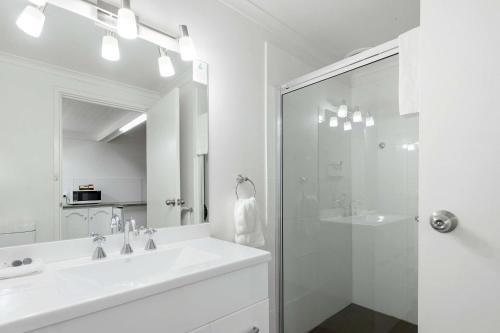 een witte badkamer met een wastafel en een douche bij Comfort Inn & Suites Riverland in Barmera