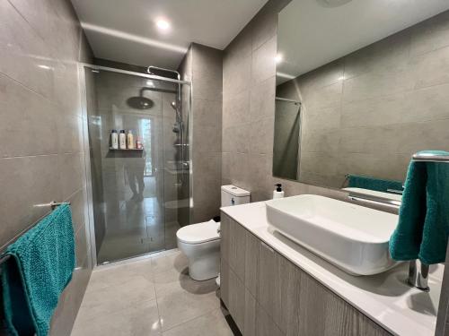 e bagno con servizi igienici, lavandino e doccia. di Embark Luxe 2BR 2Bath Apartment in Lynham 1 Secure Carpark Wifi Canberra a Canberra