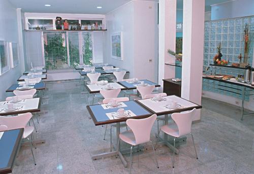 un comedor con mesas y sillas en un restaurante en Hotel Metrópolis, en São José do Rio Preto