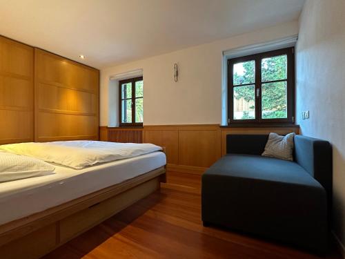 um quarto com uma cama e uma cadeira em Apartment Cesa Collina Superior em Ortisei