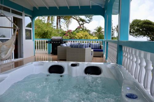a hot tub on the porch of a house at Blue Whale Villa - Penthouse in Calibishie
