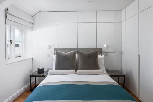 a bedroom with a large bed with white walls at FOX ON THE HOE in Plymouth