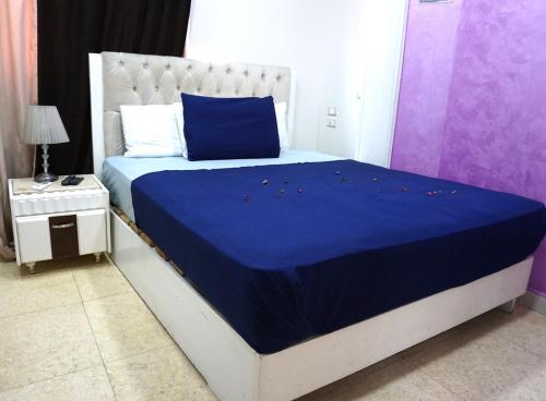a bedroom with a bed with a blue blanket on it at ABDEEN HOSTEL in Cairo