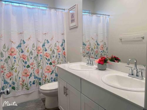 a bathroom with two sinks and a shower curtain at One -Story House With 3 Rooms in Riverside