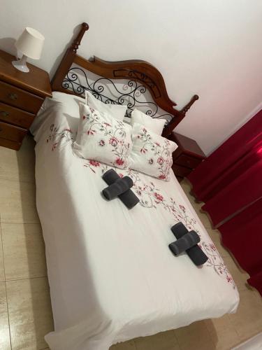 a bed with white sheets and pillows on it at Casa Estribor, vacaciones en ambiente familiar in Punta de Mujeres