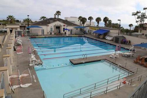 a large swimming pool with blue water at Laguna Beach Modern Home-beach across st/town 1blk in Laguna Beach