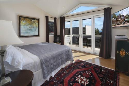 1 dormitorio con cama y ventana grande en Laguna Beach Modern Home-beach across st/town 1blk, en Laguna Beach