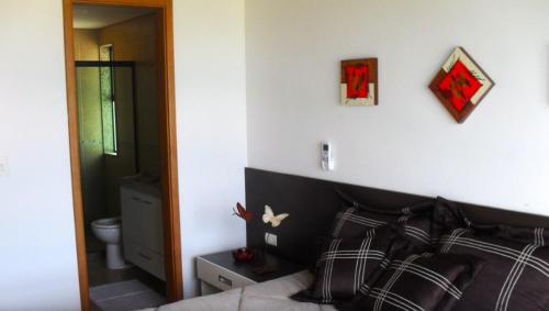 1 dormitorio con cama y pared blanca en Casa à Beira Mar, Pé na Areia, Tipo Bangalô, Piscina Privativa, Muro Alto, Porto de Galinhas PE en Porto De Galinhas