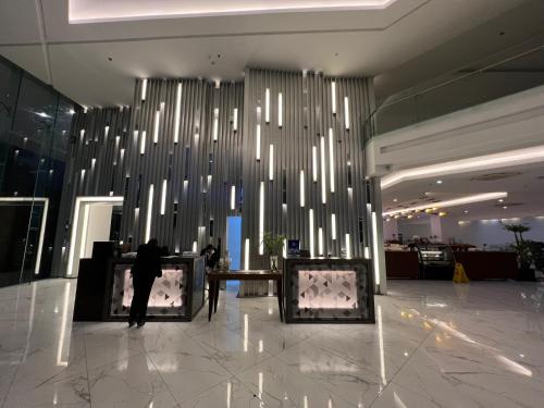 a man standing in a lobby with a large chandelier at Golden Peak Hotel & Suites powered by Cocotel in Cebu City