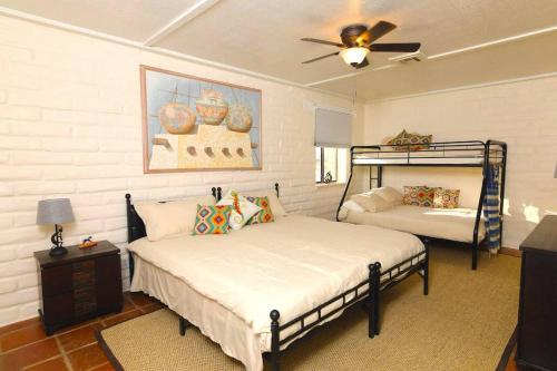 a bedroom with two beds and a ceiling fan at Cozy Adobe in Pahrump