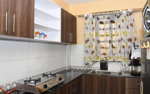 a kitchen with a stove and a sink at Intellicents Apartments in Kisumu