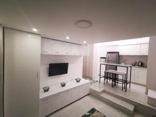 a kitchen with white cabinets and a table in it at Loft VIP in Naama bey in Sharm El Sheikh