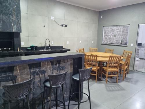 cocina y comedor con mesa y sillas en Casa - Recanto do Alesson, en Olímpia