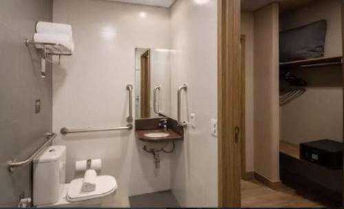 uma casa de banho com um WC, um lavatório e um espelho. em Apto Laghetto Resort Golden em Gramado