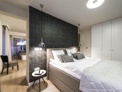 a bedroom with a large bed and a black wall at Plenty in Szczecin