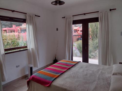 ein Schlafzimmer mit einem Bett und einem großen Fenster in der Unterkunft Luna Jatun in Purmamarca