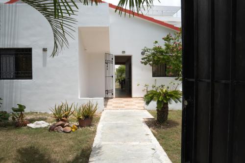 um caminho que leva a uma casa branca com plantas em Villa Rosandri em Bayahibe