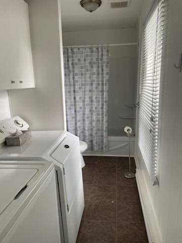eine weiße Küche mit einem Waschbecken und einer Badewanne in der Unterkunft 4 Pièces, stationnement et tennis in Saguenay