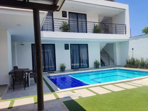 uma villa com piscina em frente a uma casa em Cabaña Milagro Bonito em Santa Marta
