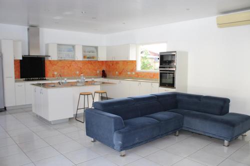 a living room with a blue couch in a kitchen at Villa Émeraude - Piscine privée sans vis à vis in Rémire-Camp