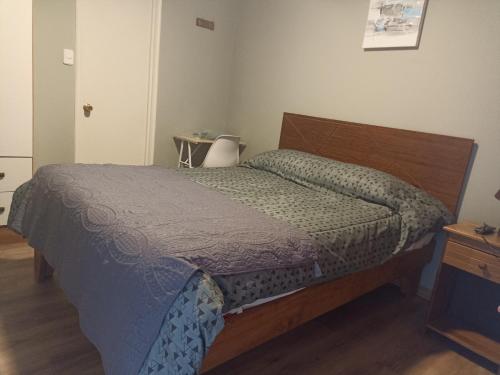 una camera con letto e testata in legno di Alojamiento jv MATRIMONIAL a Nogales