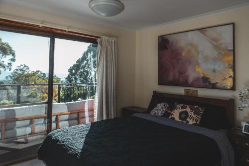 a bedroom with a bed and a large window at High Grange Luxury Mountain Retreat - Pool, Spa, Sauna in Kalorama