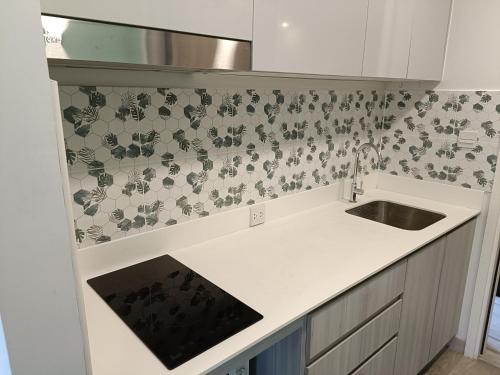a kitchen with a sink and a tile wall at The Marvest Hua Hin in Hua Hin