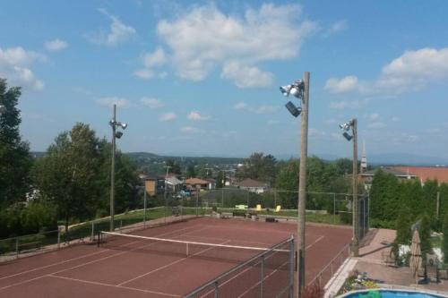 a tennis court with lights on top of it at Logement avec stationnement tennis et piscine in Saguenay