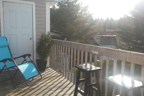 einem blauen Stuhl auf einer Terrasse mit einem Tisch in der Unterkunft Logement avec stationnement tennis et piscine in Saguenay
