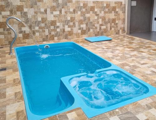 a blue tub with a water fountain on a floor at Casa - Recanto do Alesson in Olímpia