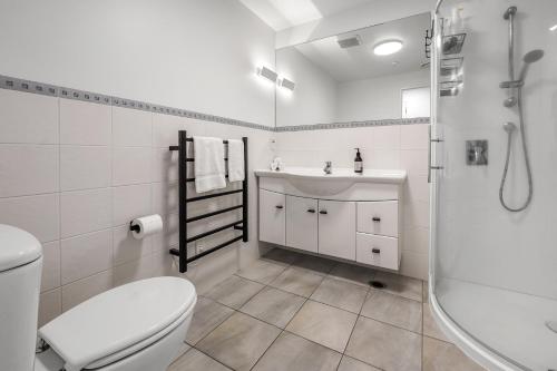 a bathroom with a toilet and a sink and a shower at Anchorage Oasis - Mt Maunganui Holiday Apartment in Mount Maunganui