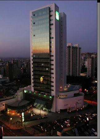 un edificio alto en una ciudad por la noche en Hotel de luxo BH, en Belo Horizonte