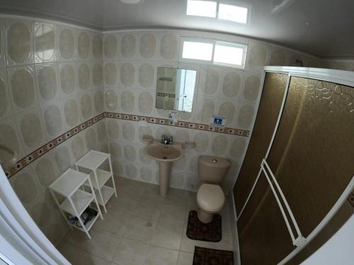 a small bathroom with a toilet and a sink at Native Lodge Brisas del Sur in Providencia