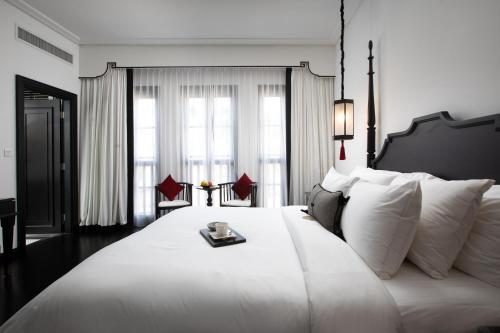 a bedroom with a large white bed with a tray on it at Liu Men Melaka in Melaka