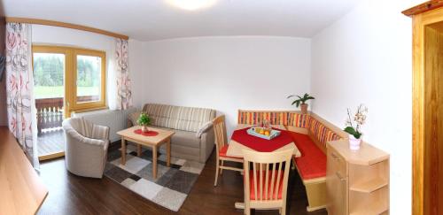 mały salon ze stołem i kanapą w obiekcie Haus Harmonika w mieście Ramsau am Dachstein