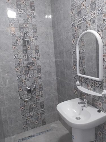 ein Bad mit einem Waschbecken und einem Spiegel in der Unterkunft Meilleure Escale à Gabes in Al Mayyitah