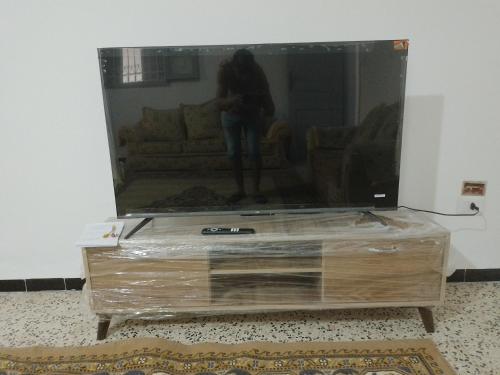 eine Person, die auf einem Fernseher auf einer Kommode steht in der Unterkunft Meilleure Escale à Gabes in Al Mayyitah