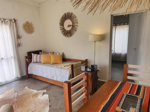 a bedroom with a bed and a table and a mirror at El Vigía del Valle in Tafí del Valle