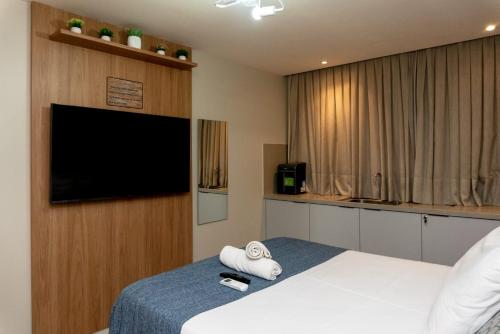 a hotel room with a bed and a flat screen tv at Apartamentos Decorados Próximos mar in João Pessoa