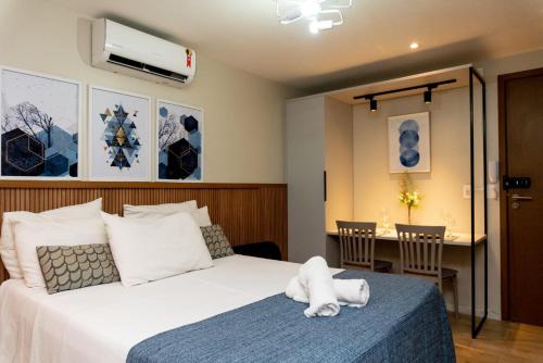 una habitación de hotel con una cama con un animal de peluche sobre una colcha azul en Apartamentos Decorados Próximos mar, en João Pessoa