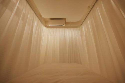 a room with a bed with a white curtain at SLEEPLAB THE STAY 渋谷 -睡眠特化型Hotel- in Tokyo