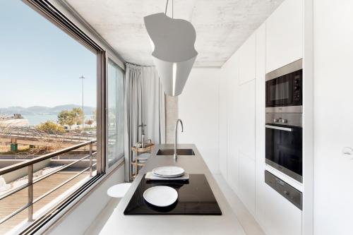 ein Esszimmer mit einem Tisch und einem großen Fenster in der Unterkunft Loft River Lisbon -with garage in Lissabon
