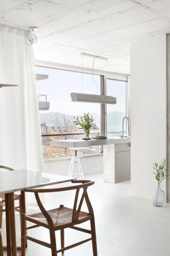 a white kitchen with a table and a chair at Beautiful design Belem Ap 115m2 in Lisbon