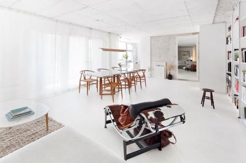 ein Wohnzimmer mit einem Stuhl und einem Tisch in der Unterkunft Loft River Lisbon -with garage in Lissabon