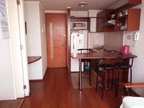 a small kitchen with a table and some stools at Metroapart 1 in Santiago