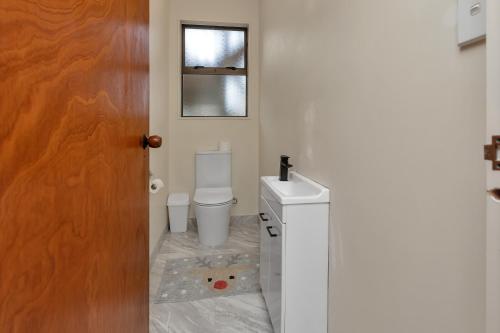 a bathroom with a toilet and a sink at Seaside on Stratford - Cable Bay Holiday Home in Cable Bay