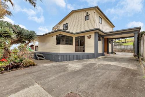 a house with a driveway in front of it at Seaside on Stratford - Cable Bay Holiday Home in Cable Bay