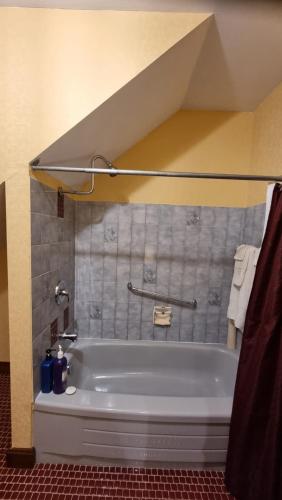 a white bath tub in a bathroom with a roof at Oceanhillside B&B in Digby