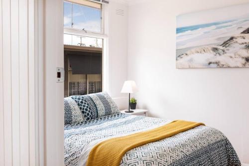 ein weißes Schlafzimmer mit einem Bett und einem Fenster in der Unterkunft Beachside Gem in Ocean Grove in Ocean Grove