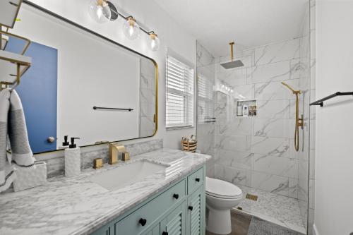 La salle de bains est pourvue d'un lavabo, de toilettes et d'un miroir. dans l'établissement Sunshine Home and Romantic Vacation, à Sarasota